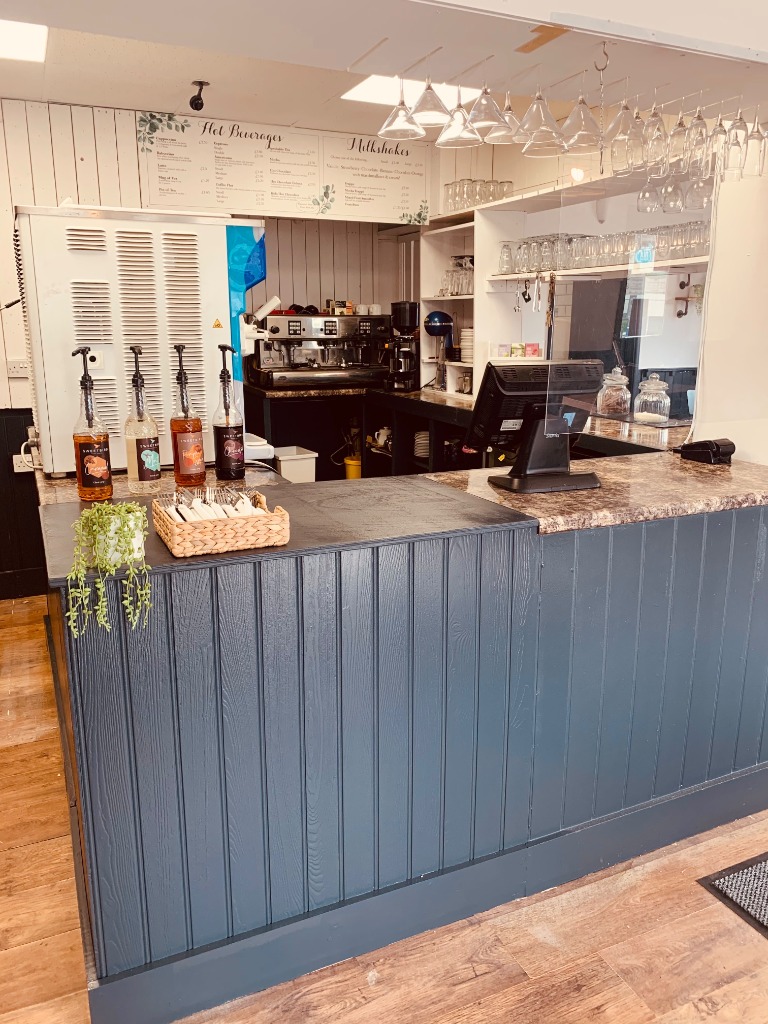 The navy-panelled counter at Coast Cafe, with the coffee machine behind it.