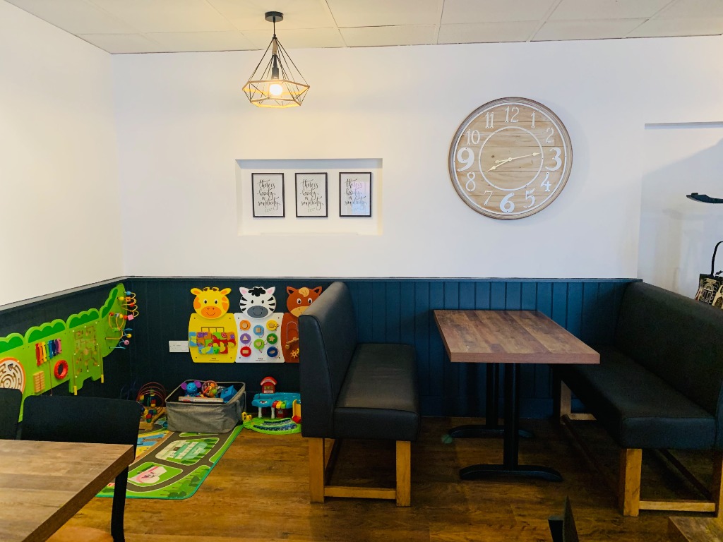Booth seating beside the children's activity area at Coast Cafe.