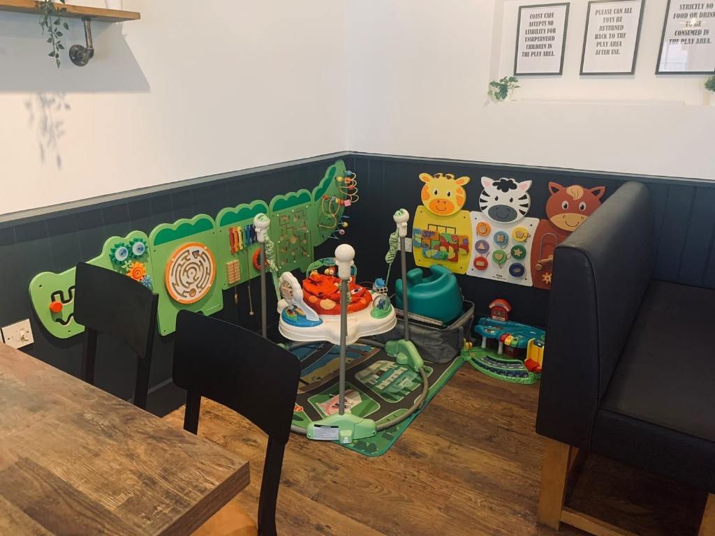 The children's play corner at Coast Cafe, with activity boards, toys and a play mat.